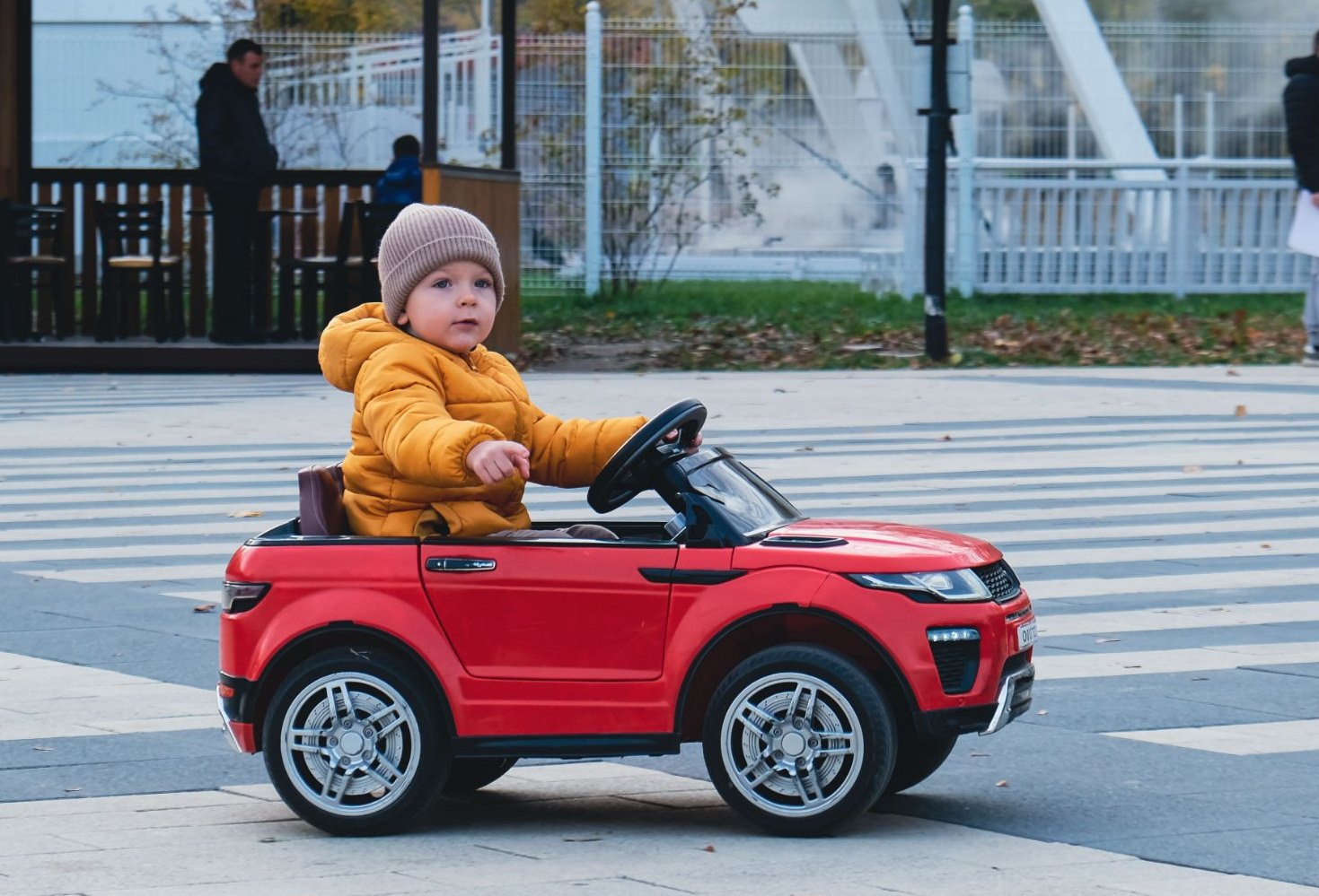 Bambino alla guida di un'auto elettrica rossa